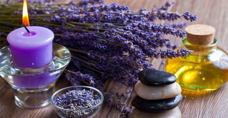 Dried lavender sprigs and essential oil bottle on linen cloth